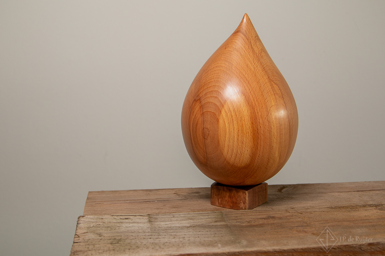 As urn van beuken hout in druppel vorm op een voetje. Uniek, persoonlijk, warm. Ook geschikt voor dieren. 