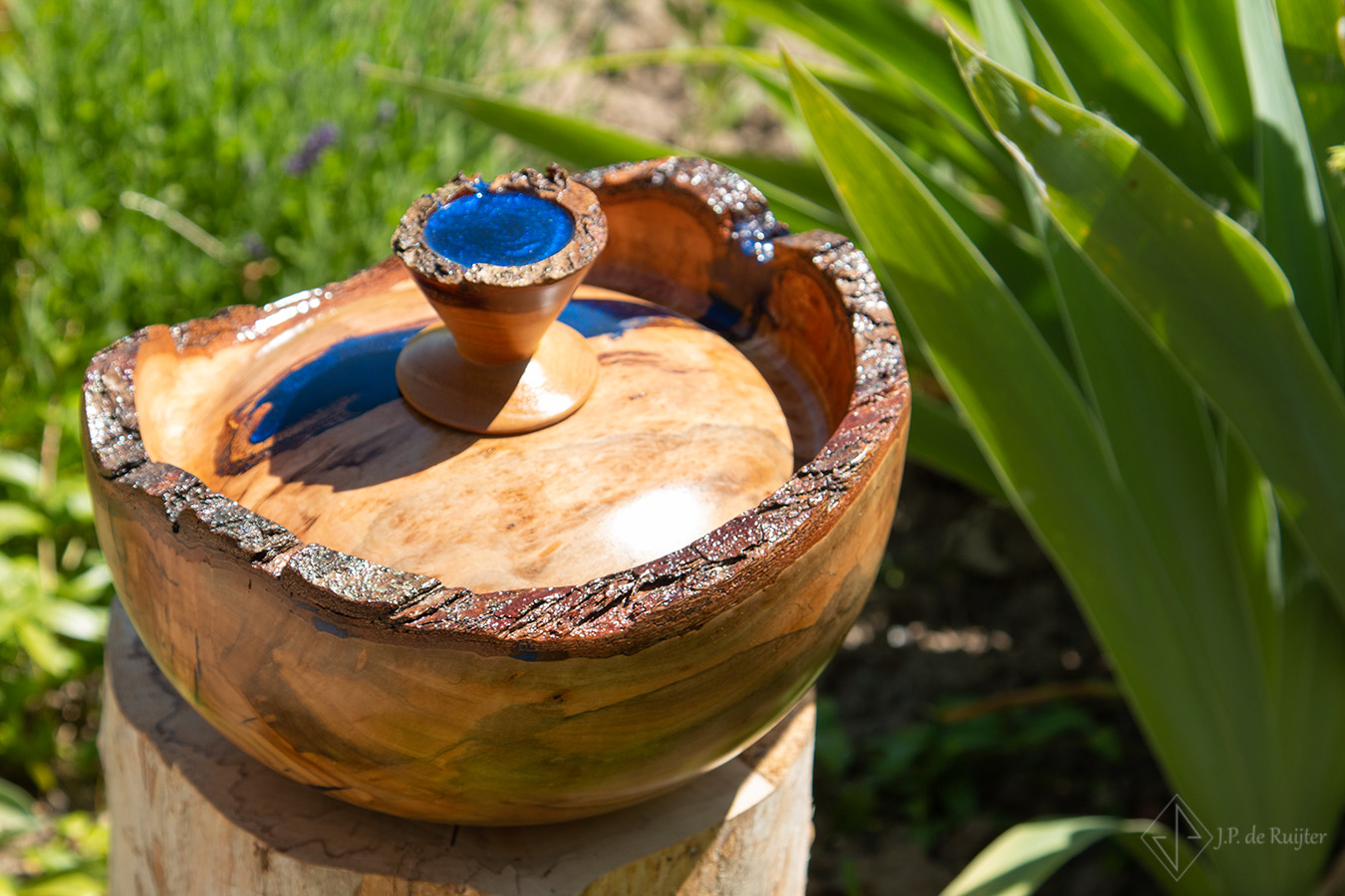 Schaal vormige as urn van hout met epoxy in blauw.